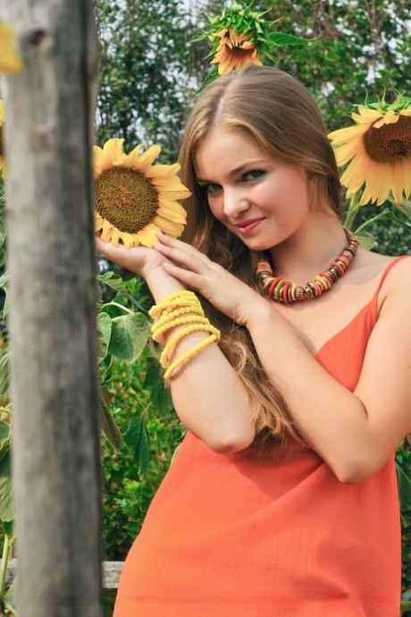 Sweet teen Bridgit A juggles little green apples amid sunflowers in the nude