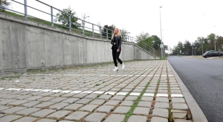 Den blonde jenta Jena Lovely trekker ned svarte leggings for å tisse i nærheten av en viadukt.