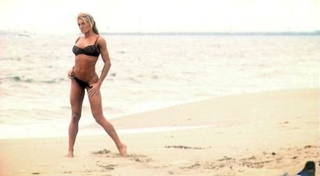 La bodybuildeuse blonde Abby Marie courbe le dos à la plage en soutien-gorge et string.