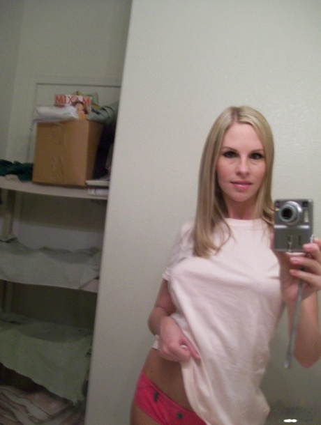 A loira amadora Aimee revela as suas mamas falsas enquanto tira selfies ao espelho