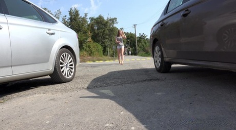 Den hvide pige Lolita trækker sine shorts ned for at tisse hurtigt mellem parkerede biler