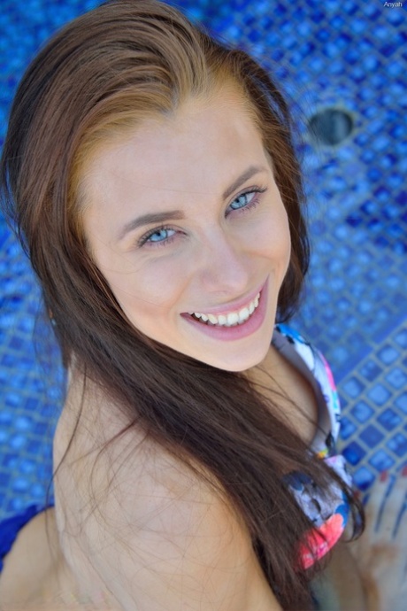 Ubrana w bikini brunetka rozkładająca cipkę przy basenie i bawiąca się tyłkiem z dildo
