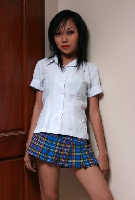Азиатская школьница стоит голая у стены во время обнаженной премьеры
