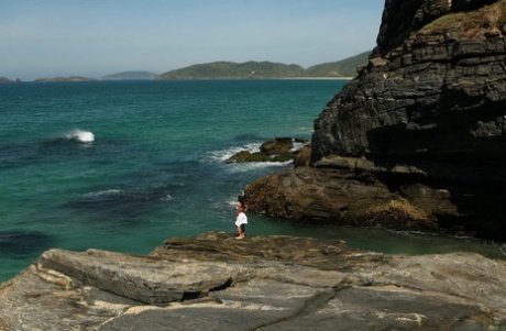 Una teenager asiatica debutta come modella nuda mentre il surf si abbatte sulla costa sottostante