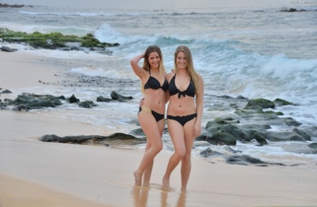 Teen lesbians Veronica and Nicole doff their bikinis for a walk on nude beach