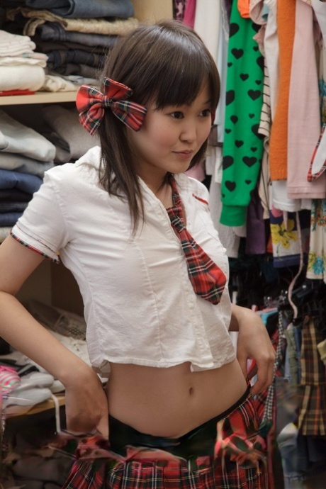 Söt asiatisk skolflicka arbetar med en vibrator i sin jungfrufitta i sitt sovrum