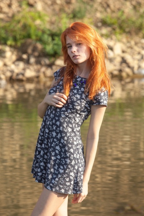 Sexy zrzavá teenagerka pózuje s nahým tělem u potoka