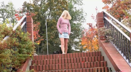 Debora, une adolescente blonde, retire sa culotte en coton pour faire pipi sur les marches en public.