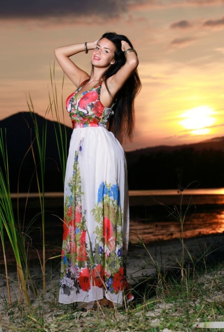 Dark-haired teen Lola Marron slips out of a long dress to pose nude at sunset