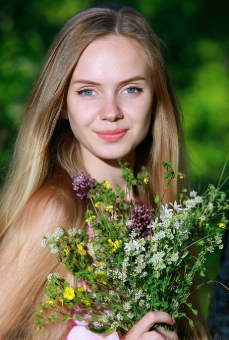 Söt tonårstjej lägger ner sina blommor och börjar posera naken