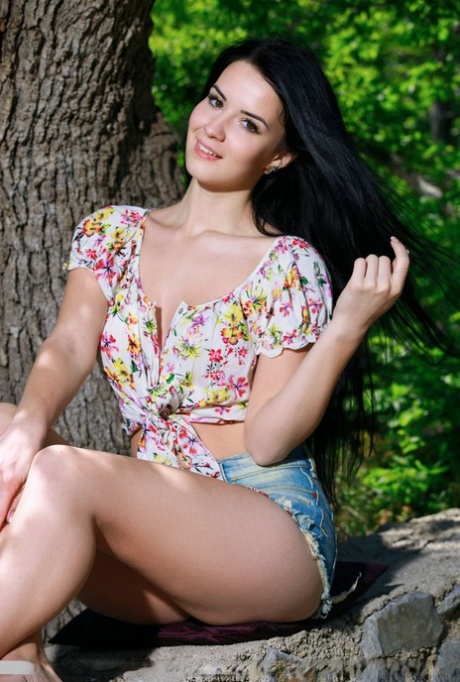 Dark haired teen Lola Marron undresses to pose nude on a stone wall