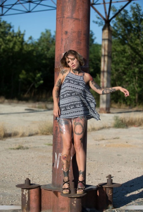 Tattooed chick Stacy Cloud works her way free of plastic wrap outdoors