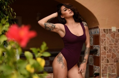 Hot brunette Mica Martinez works her tattooed figure free of a bodysuit