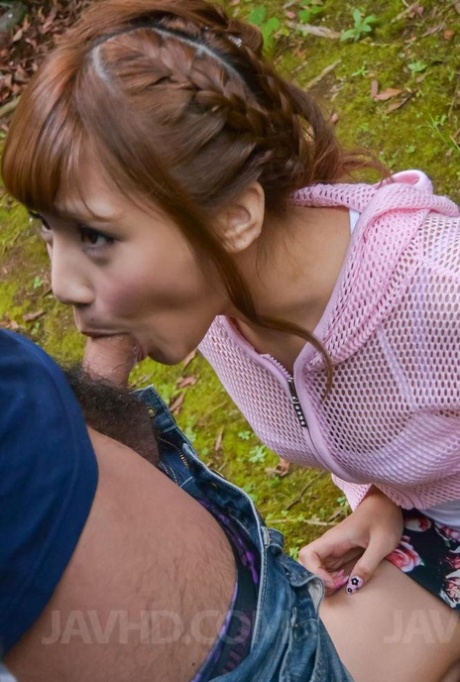 Japanese redhead Anna Anjo blows a small cock on her knees upon a lawn