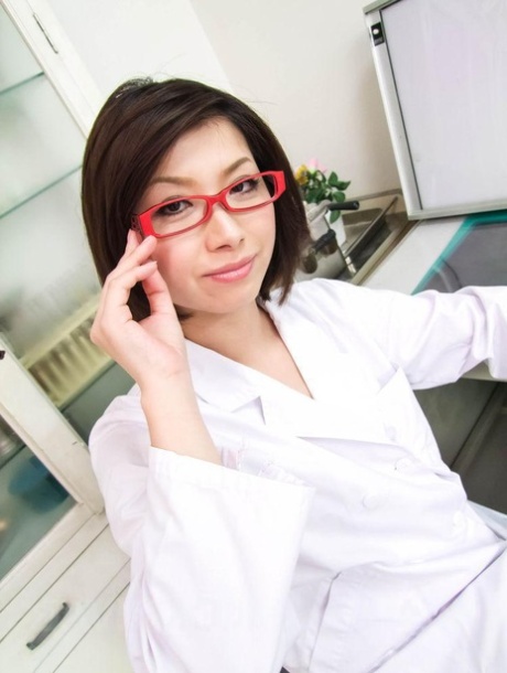 Die Japanerin Kaoru Natsuki legt ihre Brille ab, während sie in Netzstrümpfen Sex hat