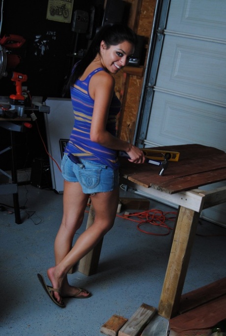 Die dunkelhaarige Kelly entledigt sich ihrer Shorts und zeigt ihren runden Hintern in der Werkstatt