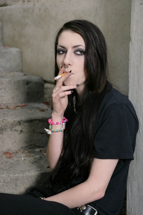 Adolescente morena fuma en una escalera antes de hacer una mamada