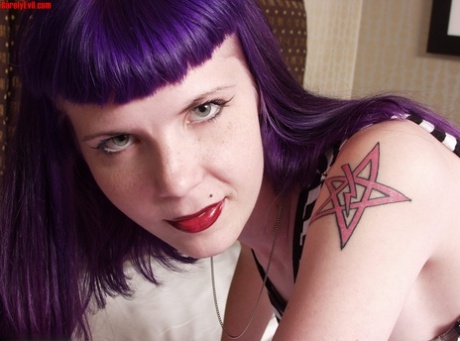 Goth girl Szandora gets totally naked on a bed while sporting purple hair