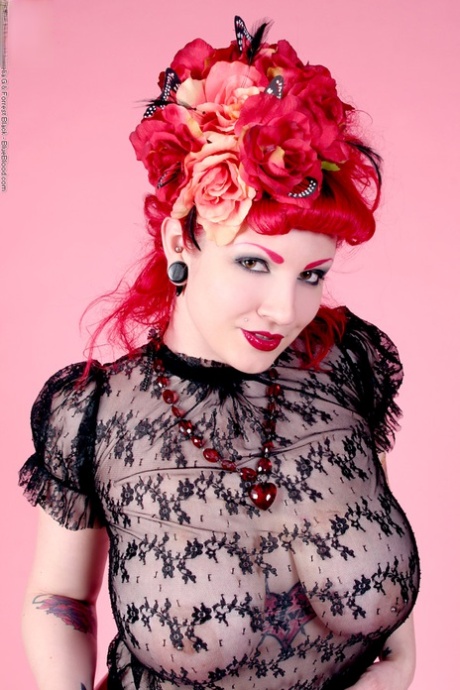 Den rødhårede model Xanthia Doll poserer nøgen i gennemsigtig bluse og latexskørt