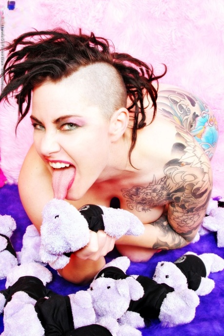 Tattooed chick Michelle Aston covers up her naked body with stuffed animals