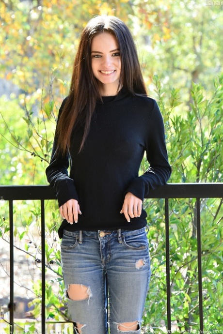 Mooi tienermeisje in gescheurde jeans ontbloot haar tieten en kale tiet op balkon