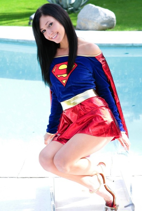 Brunetterad cosplaytjej Catie Minx klär av sig Superman-dräkten vid poolen