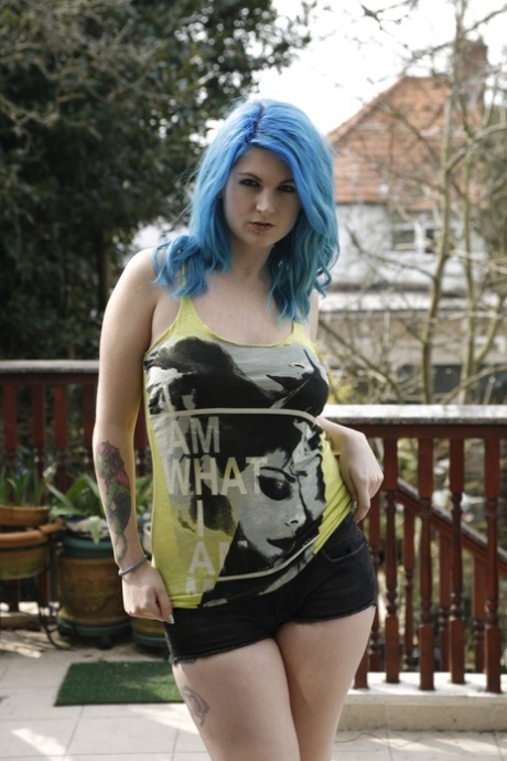 Thick amateur Emma J Black sports blue hair while stripping on a deck