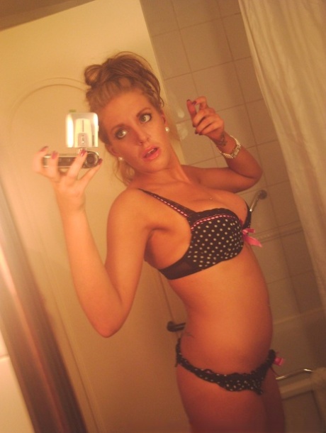 Dani Divine, une jeune fille britannique sexy, prend des selfies dans un miroir tout en se déshabillant.