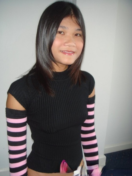Una giovane ragazza filippina si spoglia indossando calze a righe per braccia e gambe