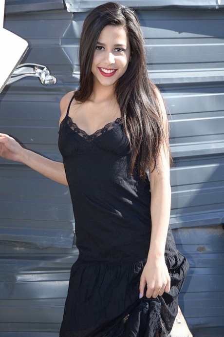 Tmavovlasá amatérka Bella Quinn modeluje černé šaty venku na skládce
