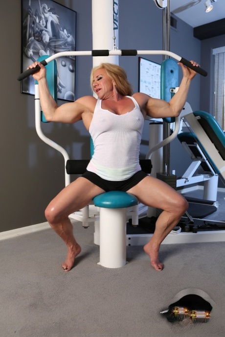 Gorąca dojrzała kulturystka Wanda Moore napina mięśnie podczas nagiego treningu na siłowni