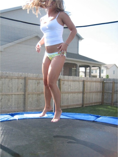 Amatérská dívka skáče na trampolíně ve spodním prádle a tričku se špagetovými ramínky