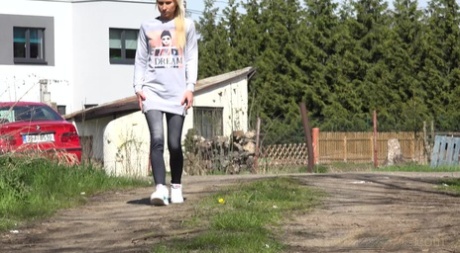 Distressed Blondine Nykla zieht ihre Jeans herunter, um auf einen Feldweg zu pinkeln