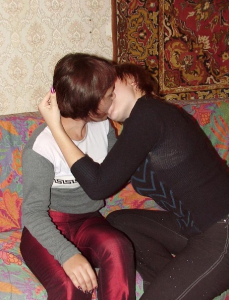 Lesbische meisjes met kort rood haar helpen elkaar naakt te worden