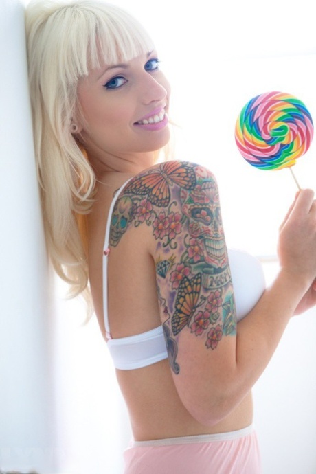 Tattooed blonde Lynn Pops strikes great poses with a lollipop in hand