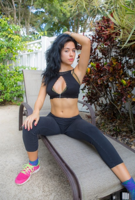 Une jeune femme amateur et sexy se glisse hors de son pantalon de yoga et de ses sous-vêtements en string.
