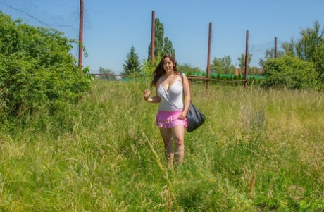 Sexy dikkerdje met enorme doorgezakte tieten kleedt zich uit om naakt te zonnen in een veld