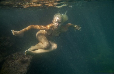 La belleza ucraniana Nika N nada bajo el agua para posar desnuda dentro de una cueva