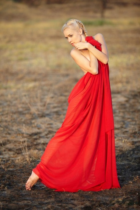 Hot blonde teen Aljena A works clear of a red gown out on the barrens