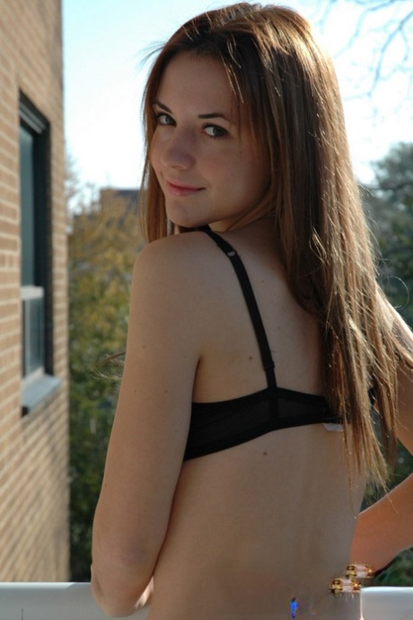 Adolescente amadora pisa na varanda do seu apartamento com sutiã e calções
