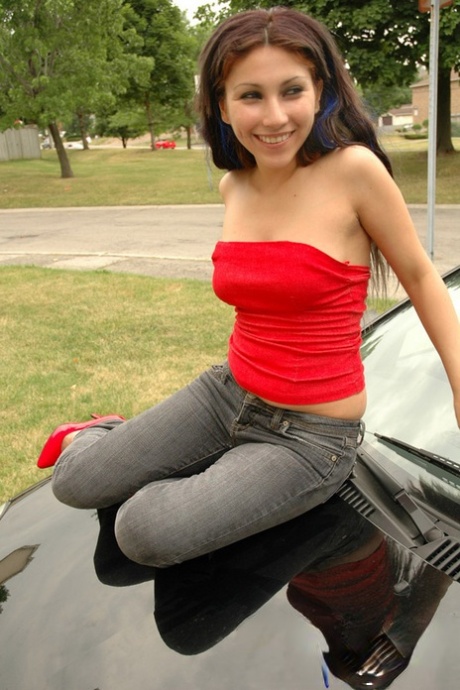 Adolescente morena expone sus tetas y y culo detrás de un coche en la entrada