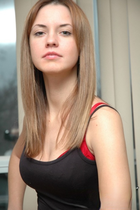 Pretty young Amy dressed in red sexy underwear bends over to show cleavage