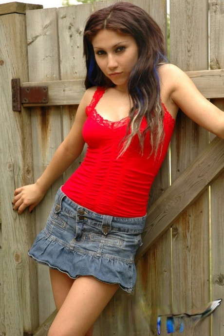 Une belle adolescente, Angel, exhibant une jupe-culotte chaude et taquinant un string en plein air.