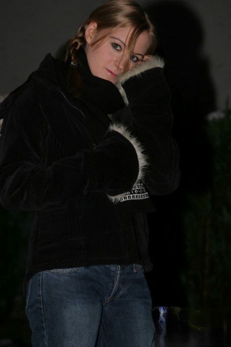 Jonge blonde Kiss Kristin laat haar platte buik zien terwijl ze buiten is in de winter