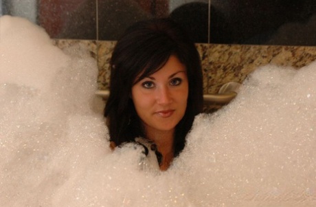 Brunett amatör Sweet Krissy modellerar naken under ett bubbelbad