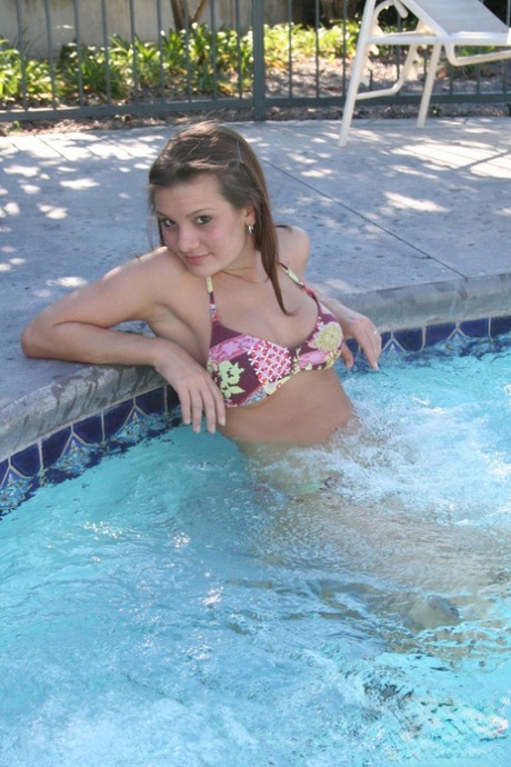 Die süße Teenagerin Kate Crush bedeckt ihre nackten Titten, nachdem sie ihr Bikinioberteil im Pool entfernt hat