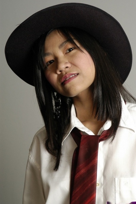 18 jaar oud Aziatisch meisje maakt haar naaktdebuut in een zwarte hoed en laarzen