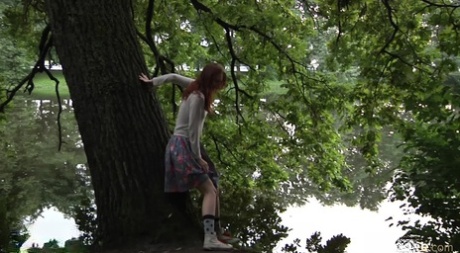 Menina solitária sobe a saia e faz xixi na floresta.