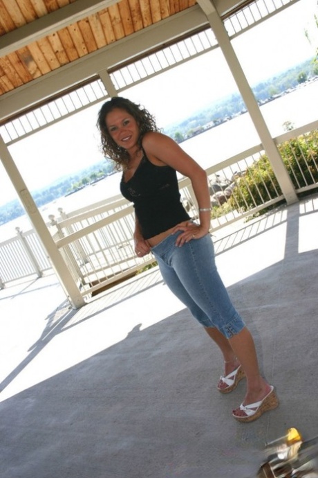 Amateur-Mädchen posiert nicht nackt auf einem Balkon in Jeans-Capris