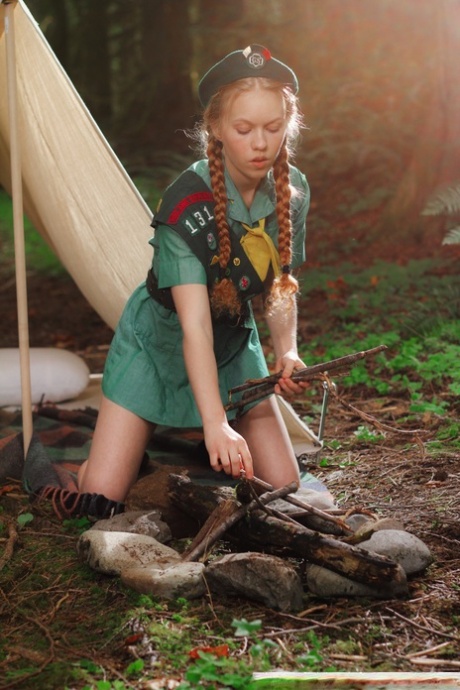 La girl scout dai capelli rossi Dolly Little si spoglia fuori dalla tenda con un berretto
